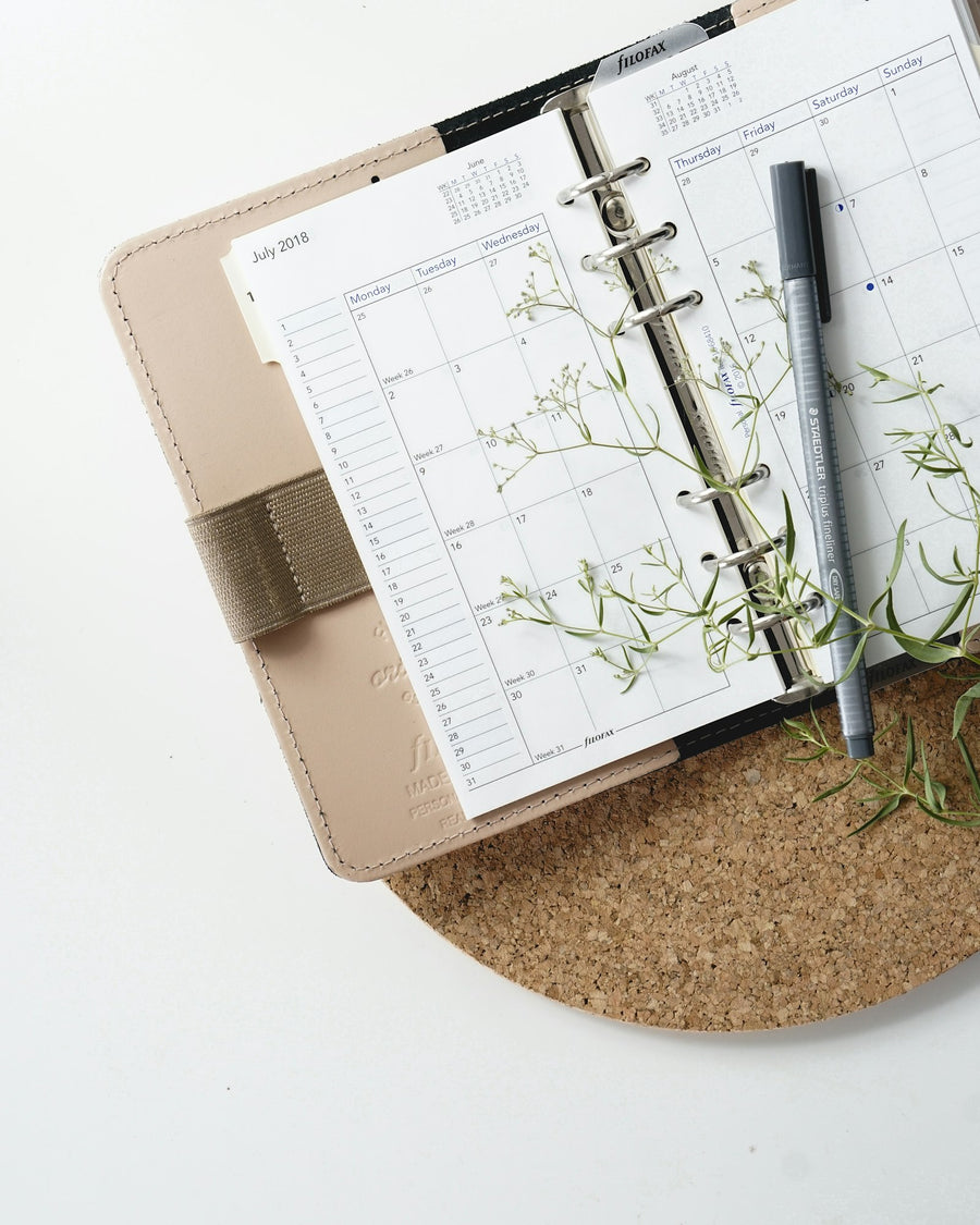 A pen resting on an open paper planner